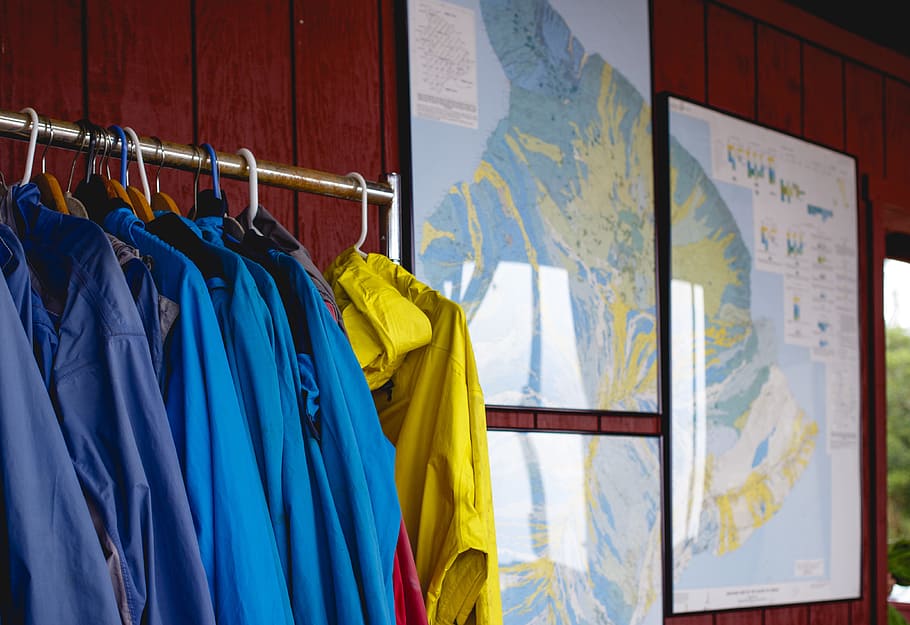 three world map photograph, assorted clothes hanging on stand