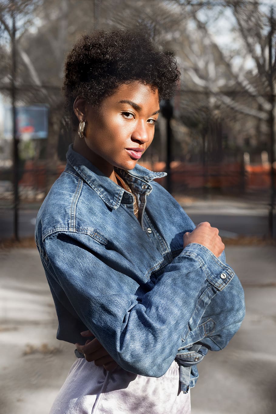selective focus photography of woman standing on park during daytime, woman wearing blue denim jacket outside during daytime HD wallpaper