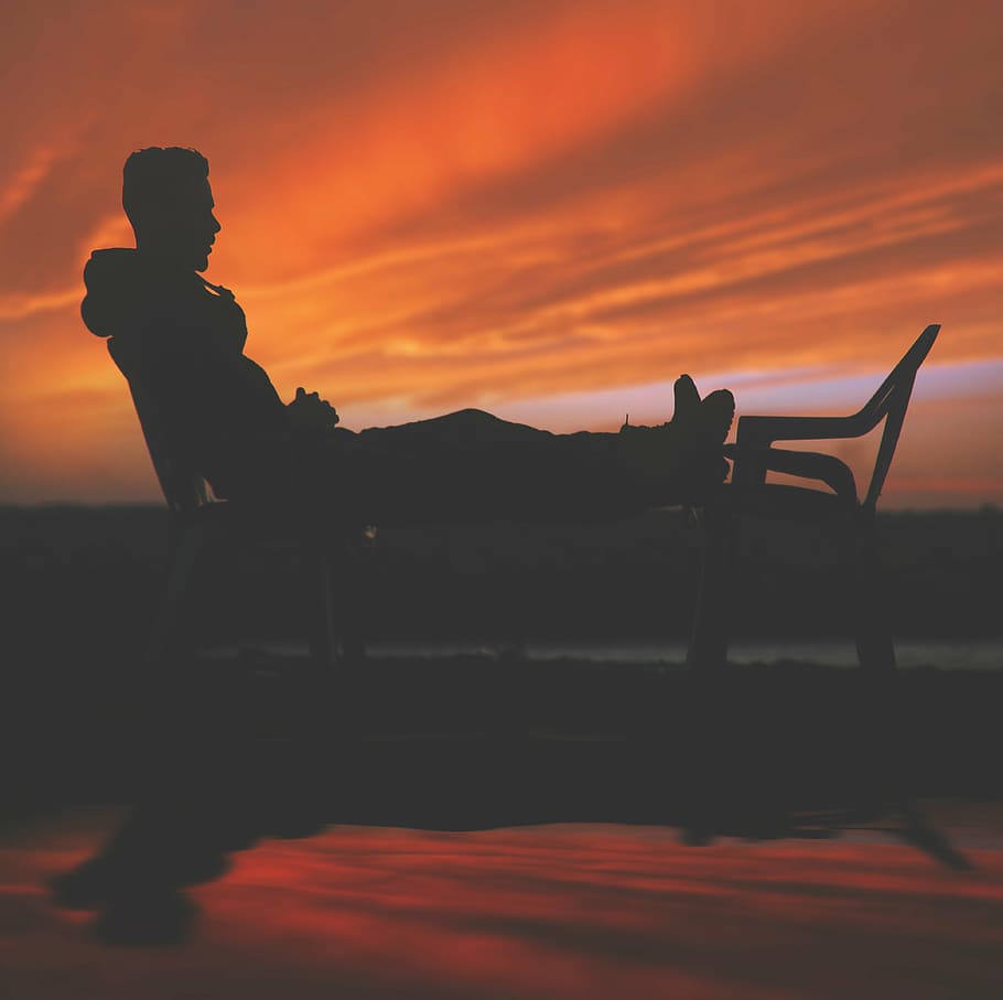 silhouette of man leaning on backrest with feet on other chair during daytime, HD wallpaper