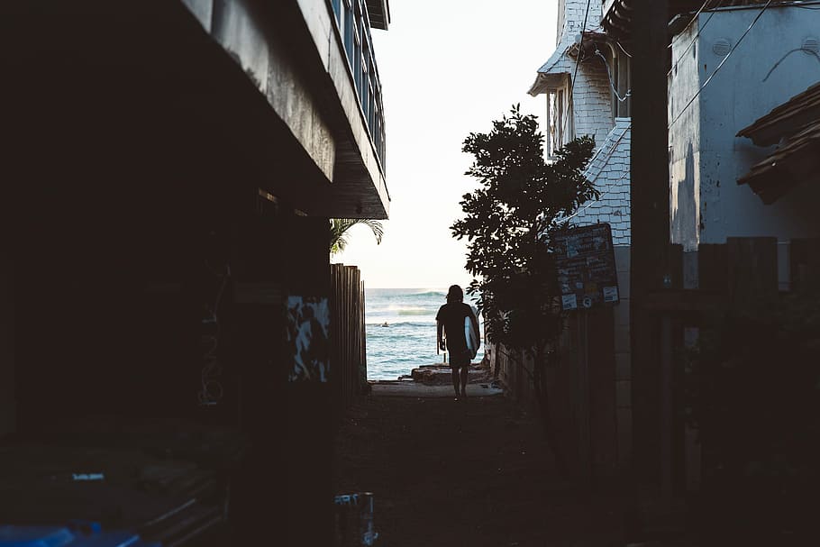 woman walking in between houses near sea shore, people, outdoors HD wallpaper