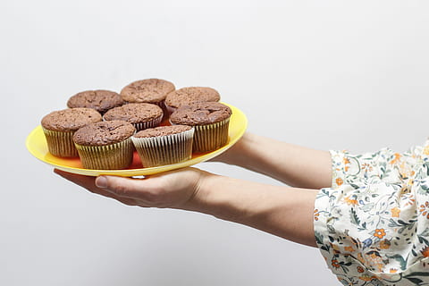 bunch of baked cupcakes, person holding yellow plate with cupcakes HD wallpaper