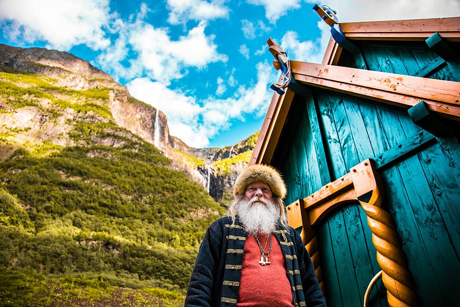 worm's eye view photography of man in front of green wooden shed, man standing beside a teal and brown wooden house HD wallpaper