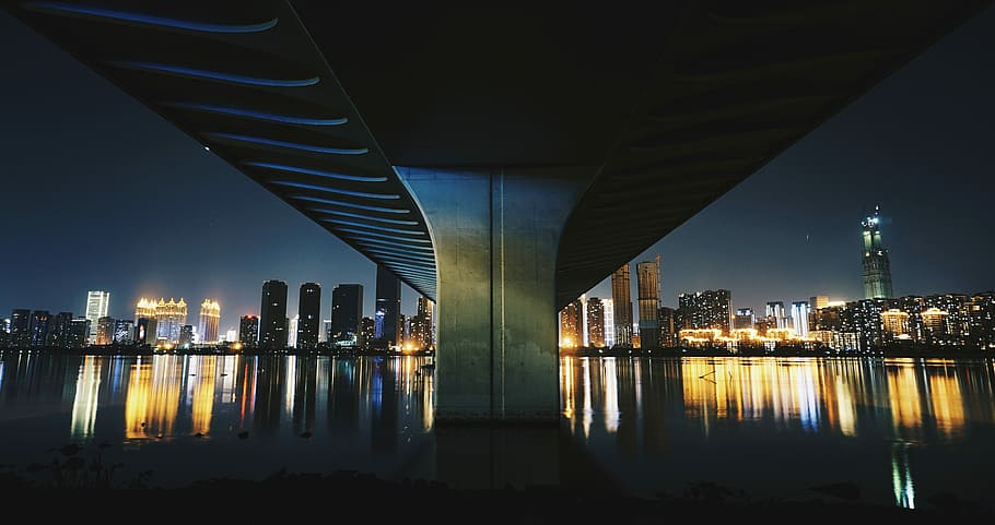 gray concrete bridge between city skyline during night time, structural photography of bridge HD wallpaper