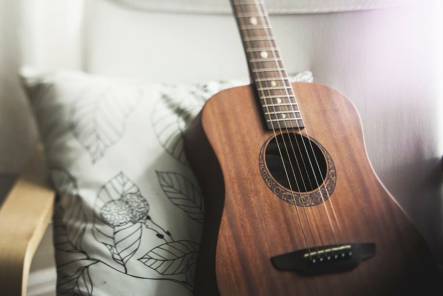 selective focus photo of brown acoustic guitar leaning on white and black floral throw pillow, HD wallpaper