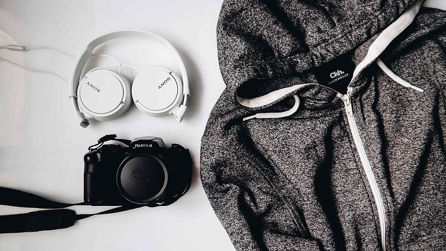 black DSLR camera and white Sony wireless headphones beside gray and white zip-up hooded jacket, zip-up hoodie beside DSLR camera and Sony headphones, HD wallpaper
