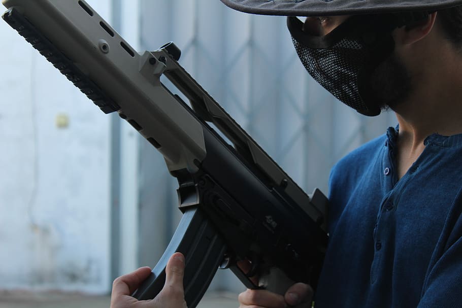 man holding rifle with mask on face, gun, facemask, hat, weapon HD wallpaper