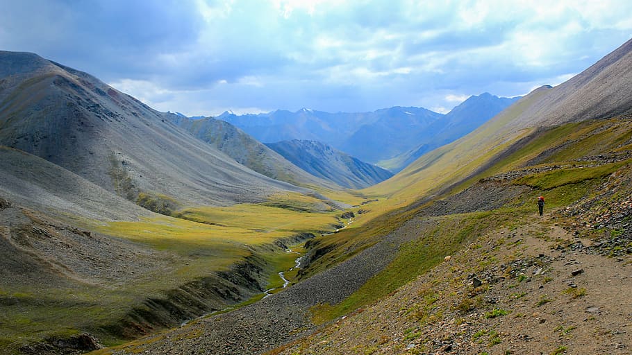 brown mountains view under blue cloudy sky, person standing on mountain HD wallpaper