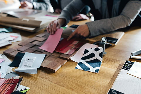 Designers working with material samples and paper cutouts, fabric HD wallpaper