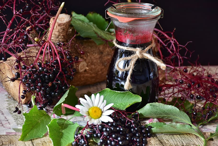 black and red fruit near glass bottle on top of brown wooden surface HD wallpaper