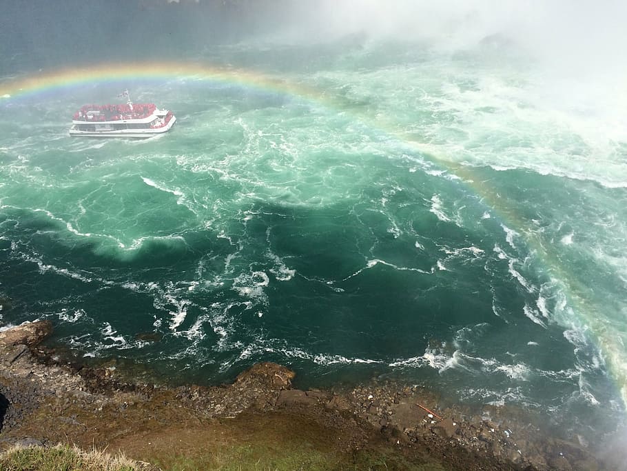 red cruiser ship traveling during daytime, whitewater, rainbow