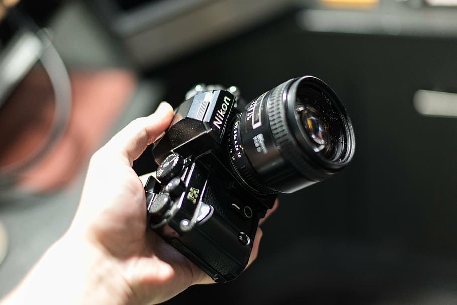 person holding black Nikon DSLR camera, mirrorless, tilt, shift HD wallpaper