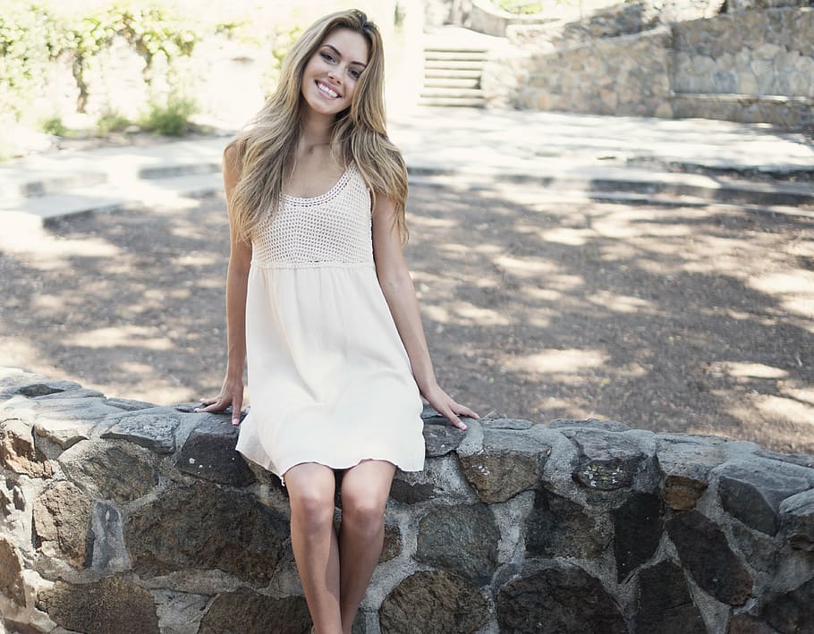 woman in white dress sitting on rock fence, beautiful, girl, smiling, HD wallpaper