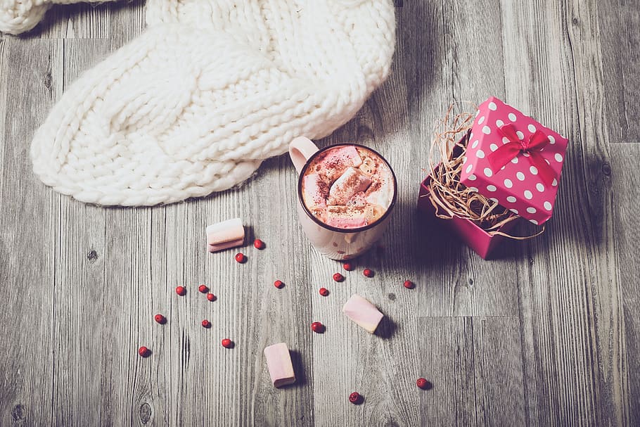 pink glass mug beside knitted textile on brown wooden surface HD wallpaper