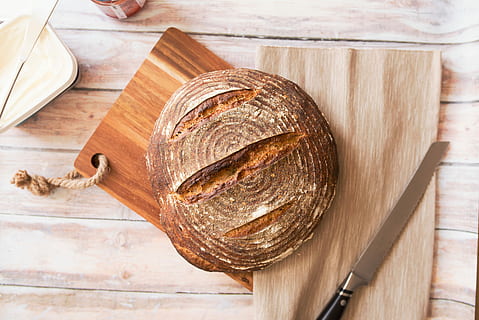 closeup photo of baked bread on chopping board, round pastry on brown wooden chopping board HD wallpaper