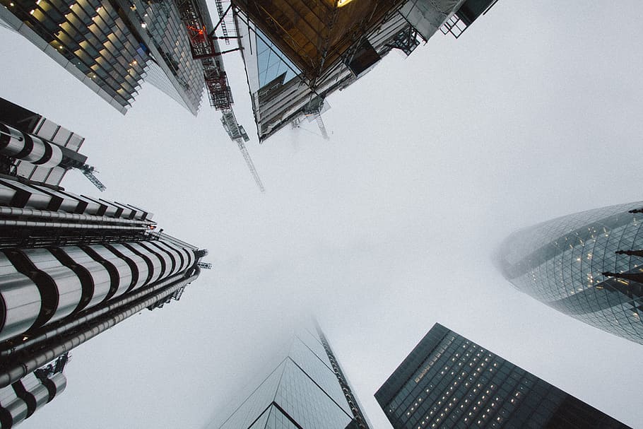 low angle photo of high rise building covered with fog, photography of high-rise buildings under the cloudy sky HD wallpaper