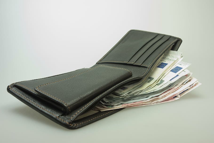 black leather bifold wallet filled with banknotes, money, purse