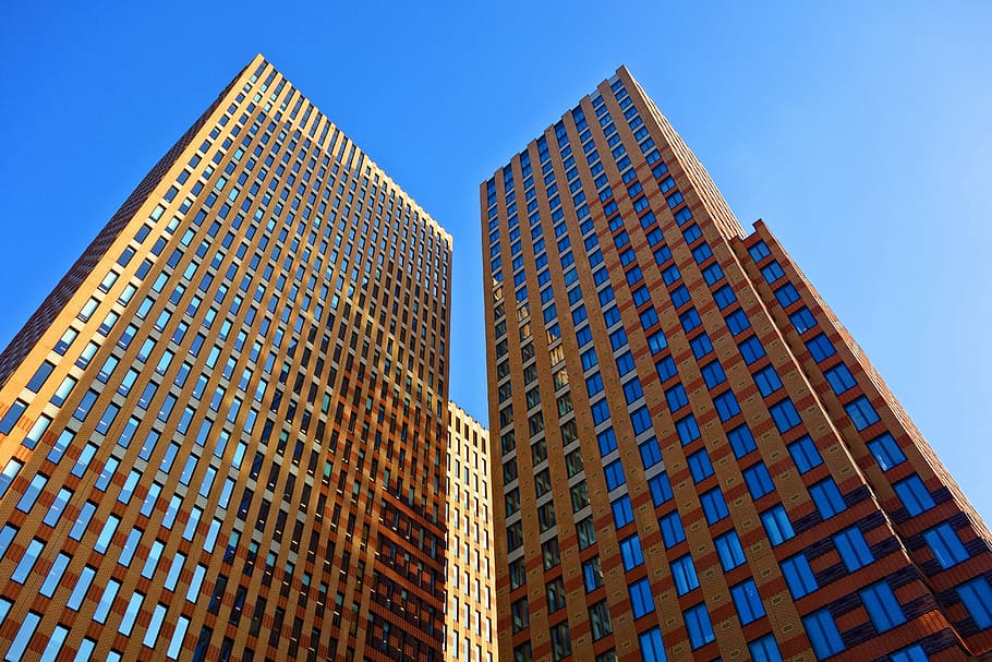 worm view photography of two brown buildings during daytime HD wallpaper