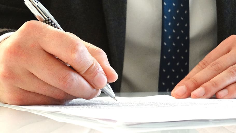 person holding grey pen, legal, attorney, jurist, signature, documents