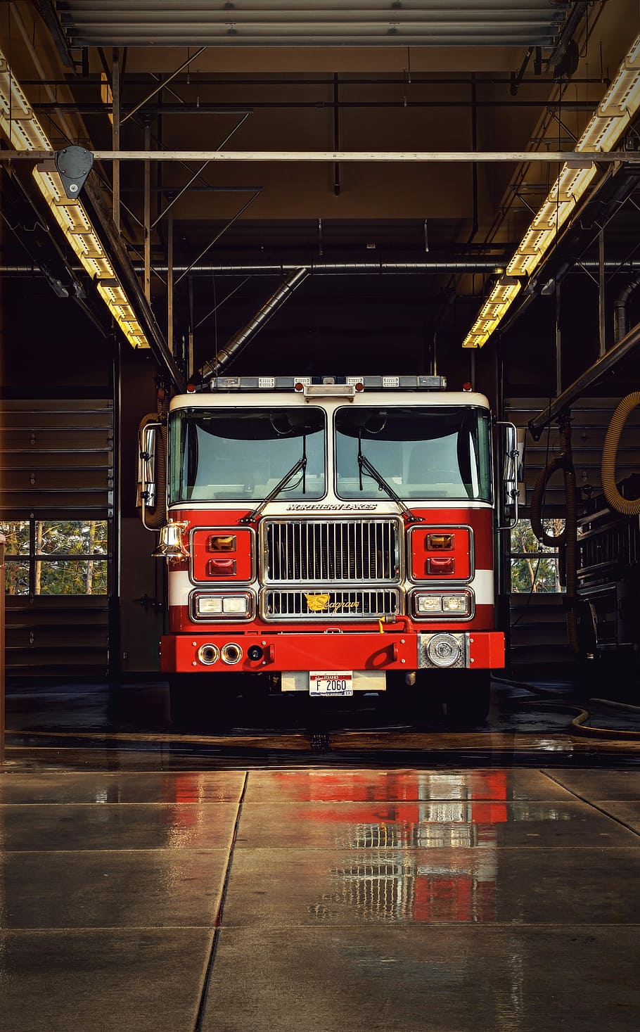 red firetruck on garage, red firetruck parked on building, fire truck