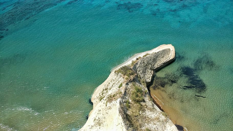aerial photography of island during daytime, island with green trees next to sea water HD wallpaper