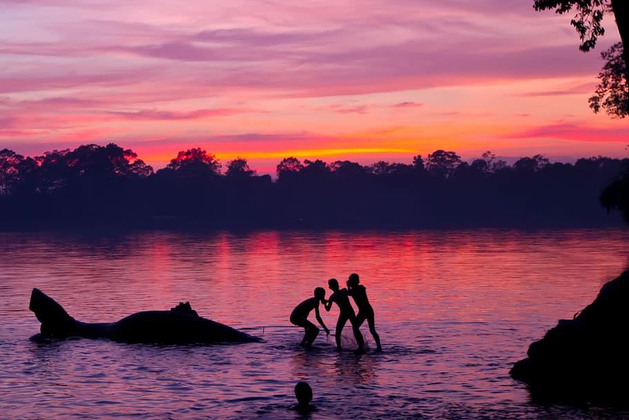 silhouette of children playing on lake, silhouette of four persons on body of water at golden hour HD wallpaper