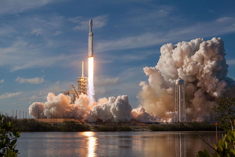 gray spacecraft taking off during daytime, space rocket with fire blown below and smoke spreads near body of water HD wallpaper