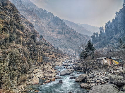 house near river surrounded with mountains, river in between mountain, house and trees at daytime HD wallpaper