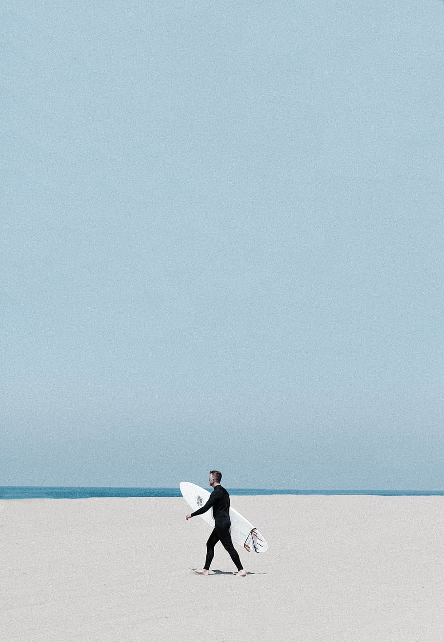 man wearing black wetsuit holding white surfboard walking on shoreline, HD wallpaper