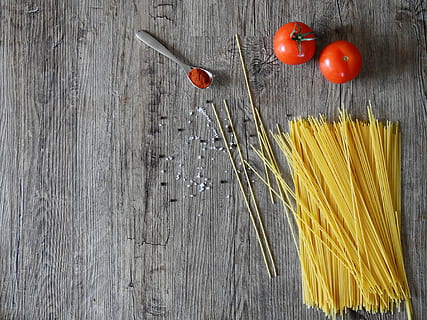 uncooked pasta and two red tomato fruits on grey wooden surface HD wallpaper