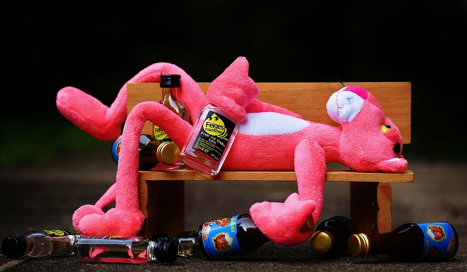 pink panther plush toy laying on brown wooden bench near liquor bottles, HD wallpaper