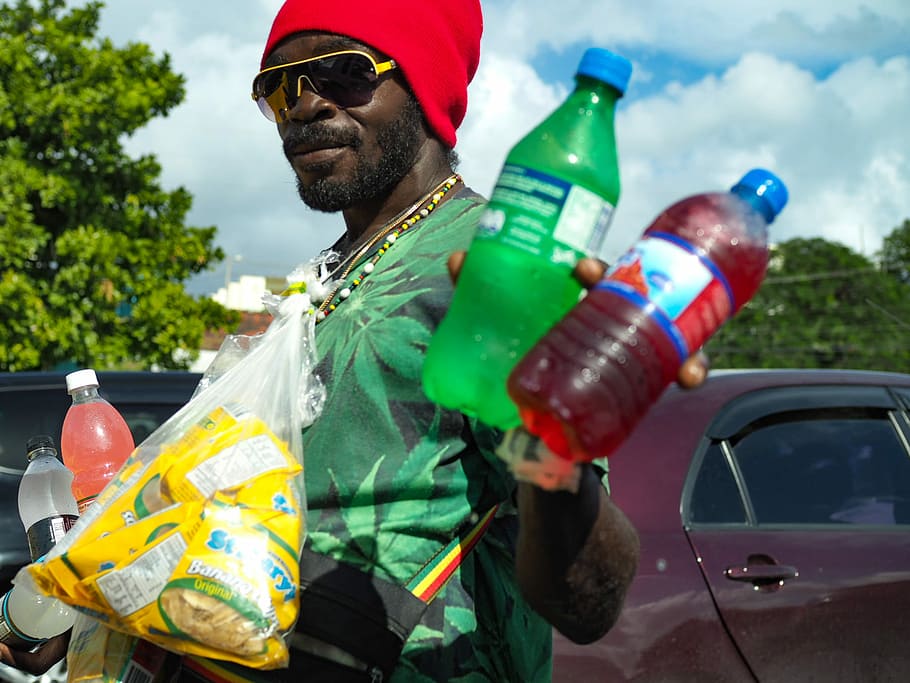 man wearing green t-shirt holding two Sprite and blue labeled bottles, man holding plastic bottles HD wallpaper