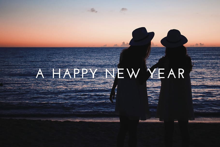A happy new year text with background of woman walking on the beach at sunset view HD wallpaper