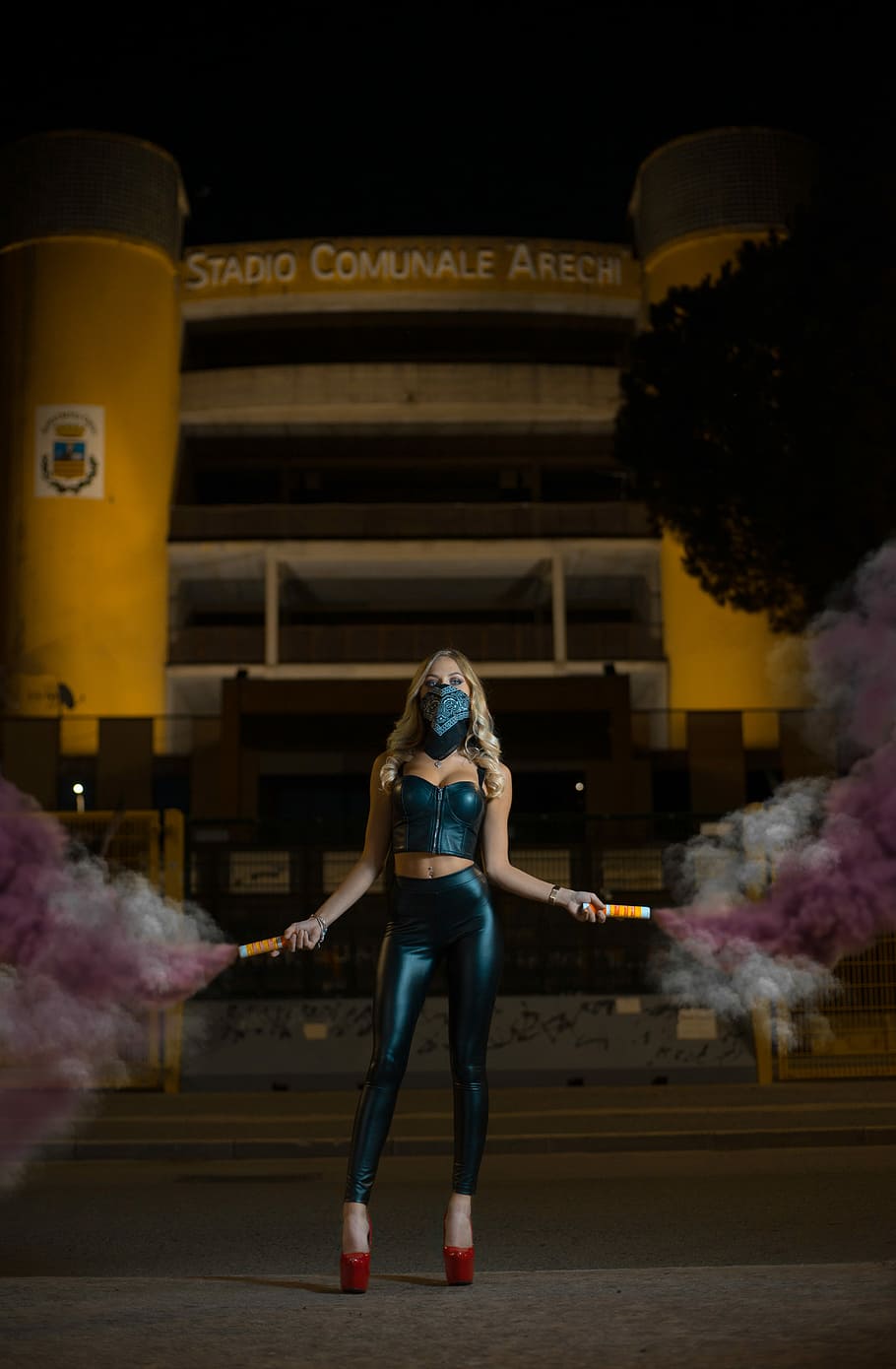 woman standing on pavement holding smoke bombs during night time, woman standing in front of Stadio Comunale Arechi building while holding purple powder spray, HD wallpaper