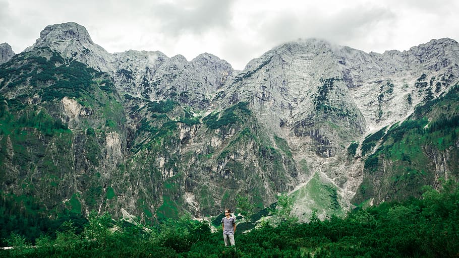 man standing on green grass with mountain in background, nature HD wallpaper