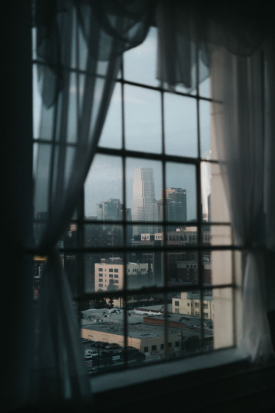 opened white window curtain, overlooking city buildings through glass windows HD wallpaper