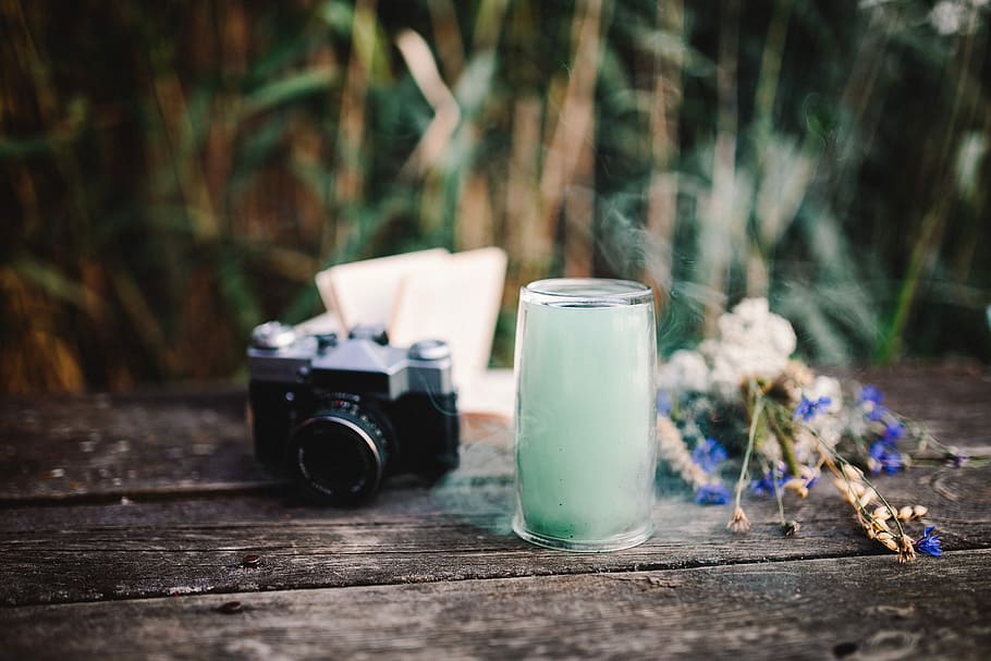 Colorful smoke bomb, book and vintage camera, wooden desk, wooden pier