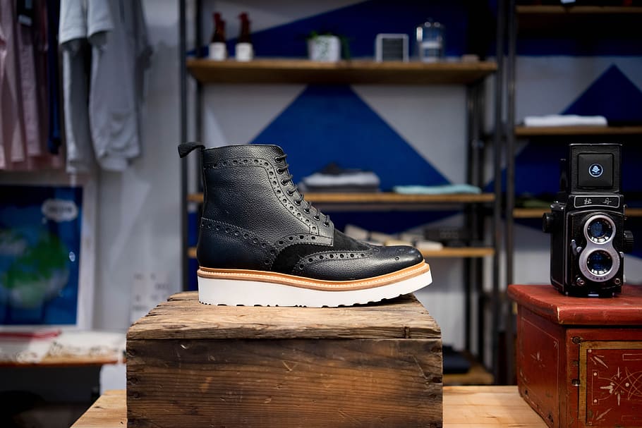 unpaired black and brown boot, unpaired black leather shoe beside vintage camera HD wallpaper