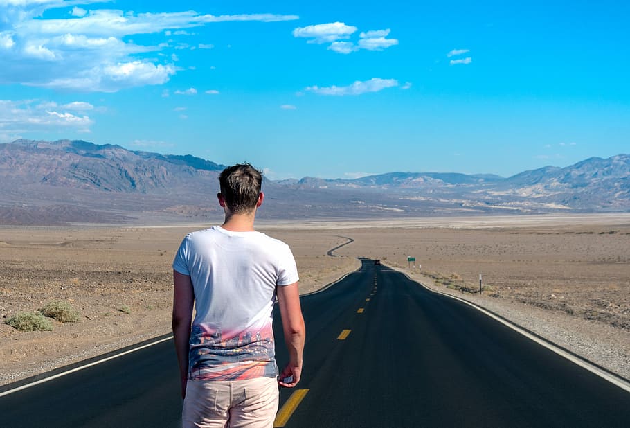 man standing in the middle of the road, man standing on gray pave road during daytime HD wallpaper