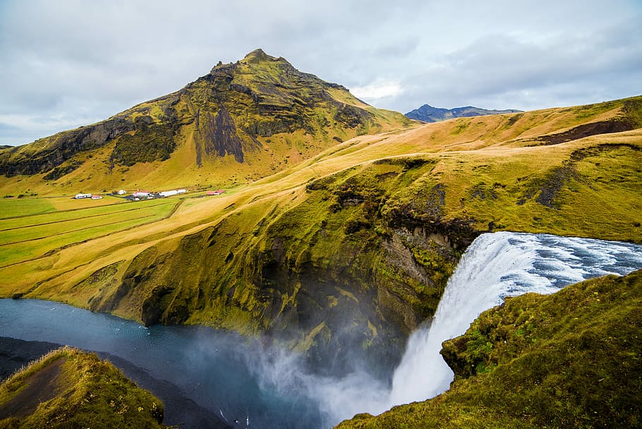 green mountain, waterfalls near brown and black mountain under white and blue sky at daytime HD wallpaper