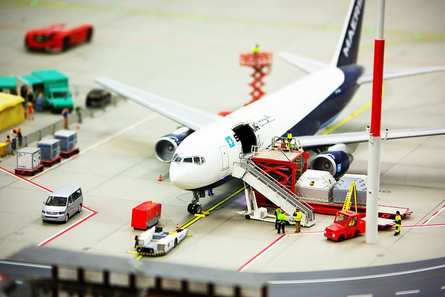 white and black Airliner scale model with car die-cast, airport