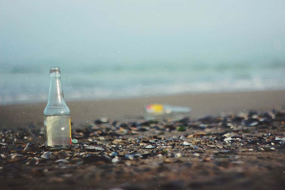 glass bottle on sea shore, tilt shift lens photography of bottle on seashore HD wallpaper