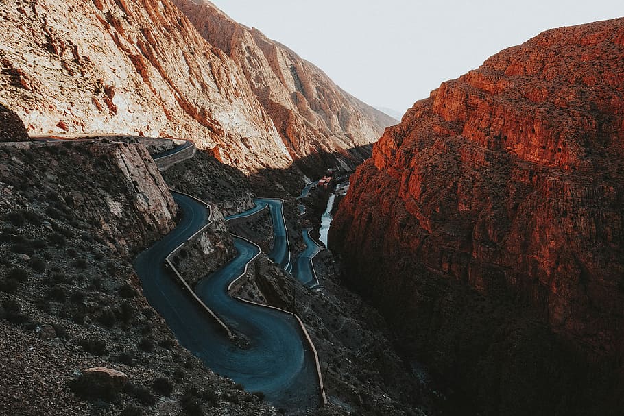 asphalt road beside mountains, photography of river surrounded by mountains during daytime HD wallpaper
