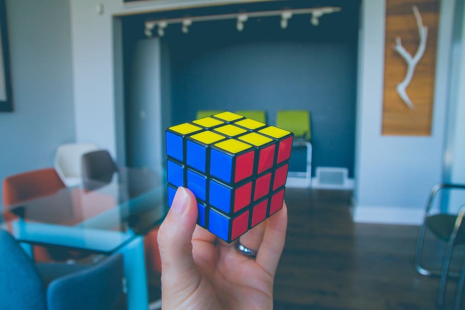 selective focus photography of person holding Rubik's Cube HD wallpaper