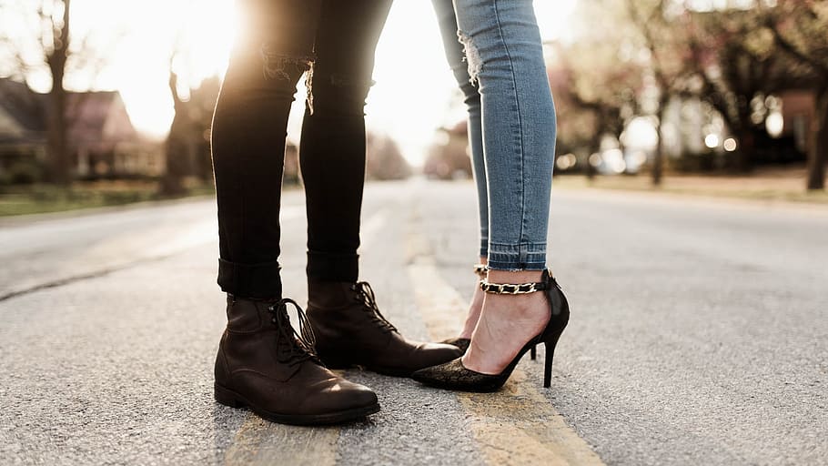 worm's eye view photography of man and woman facing each other, woman wearing stiletto standing next to man wearing boot on cement pavement during daytime, HD wallpaper