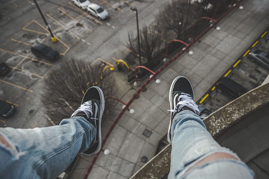 man sitting on rooftop selective focus photography, person sitting on building top HD wallpaper