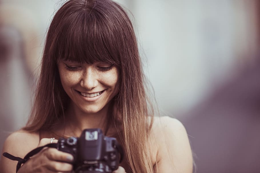 selective focus photography of smiling woman holding camera, selective focus photography of woman smiling looking picture DSLR camera HD wallpaper