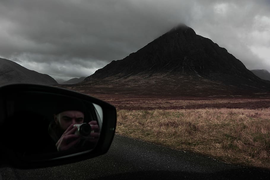 Exploring the Mountains, person taking picture inside vehicle under cloudy sky