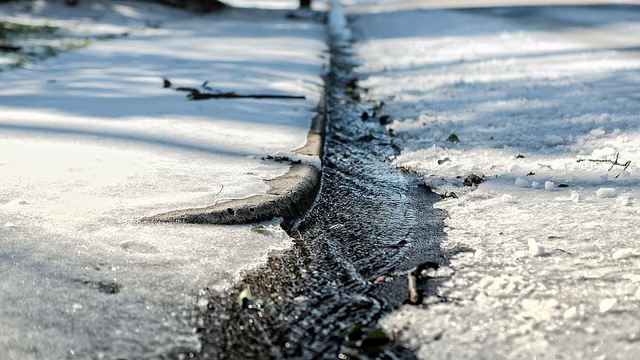 close-up photography of flowing water between concrete road HD wallpaper
