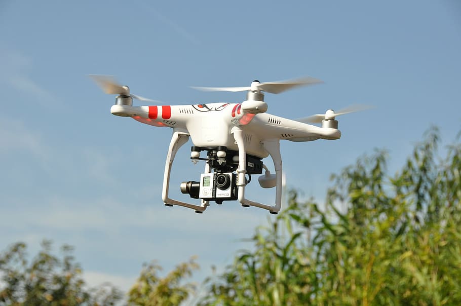 red and white DJi Phantom drone hovering on sky near tree during day, HD wallpaper