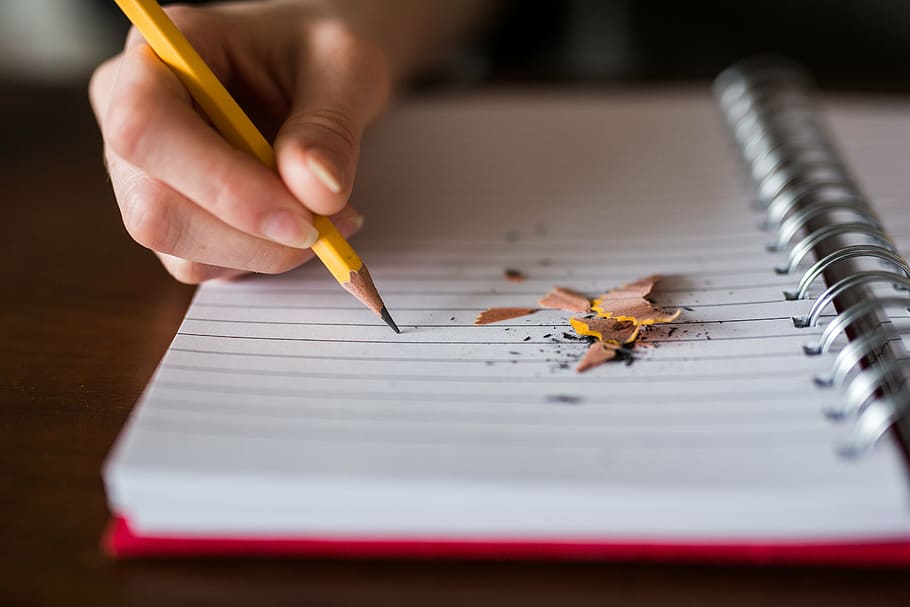 person writing on a black lined notebook, pencil, write, school HD wallpaper